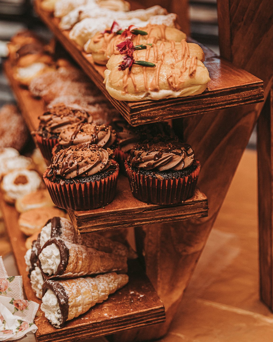 Assortment of pastries and cupcakes on a wooden stand.