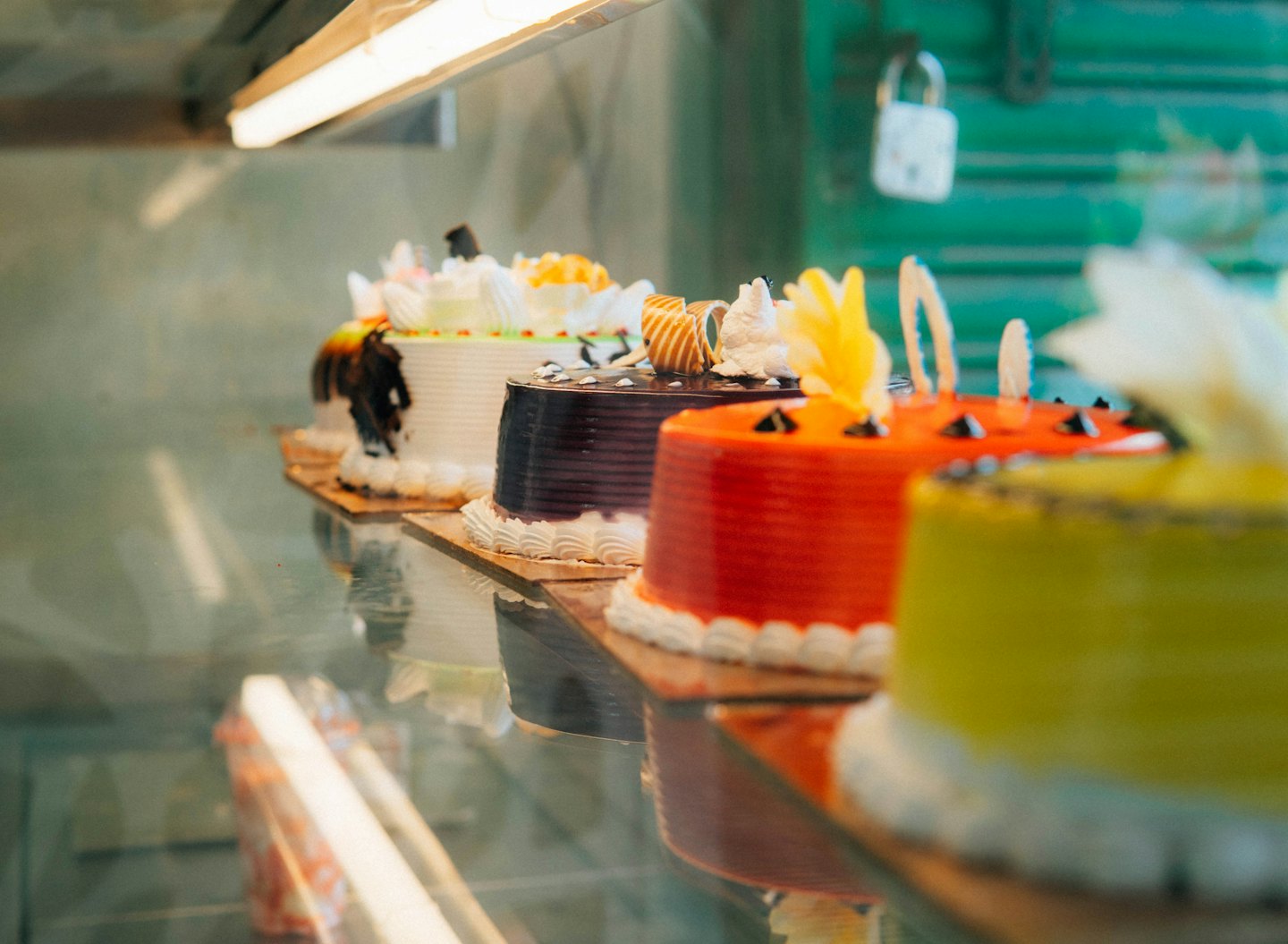 Whole decorated cakes displayed in a glass bakery case.