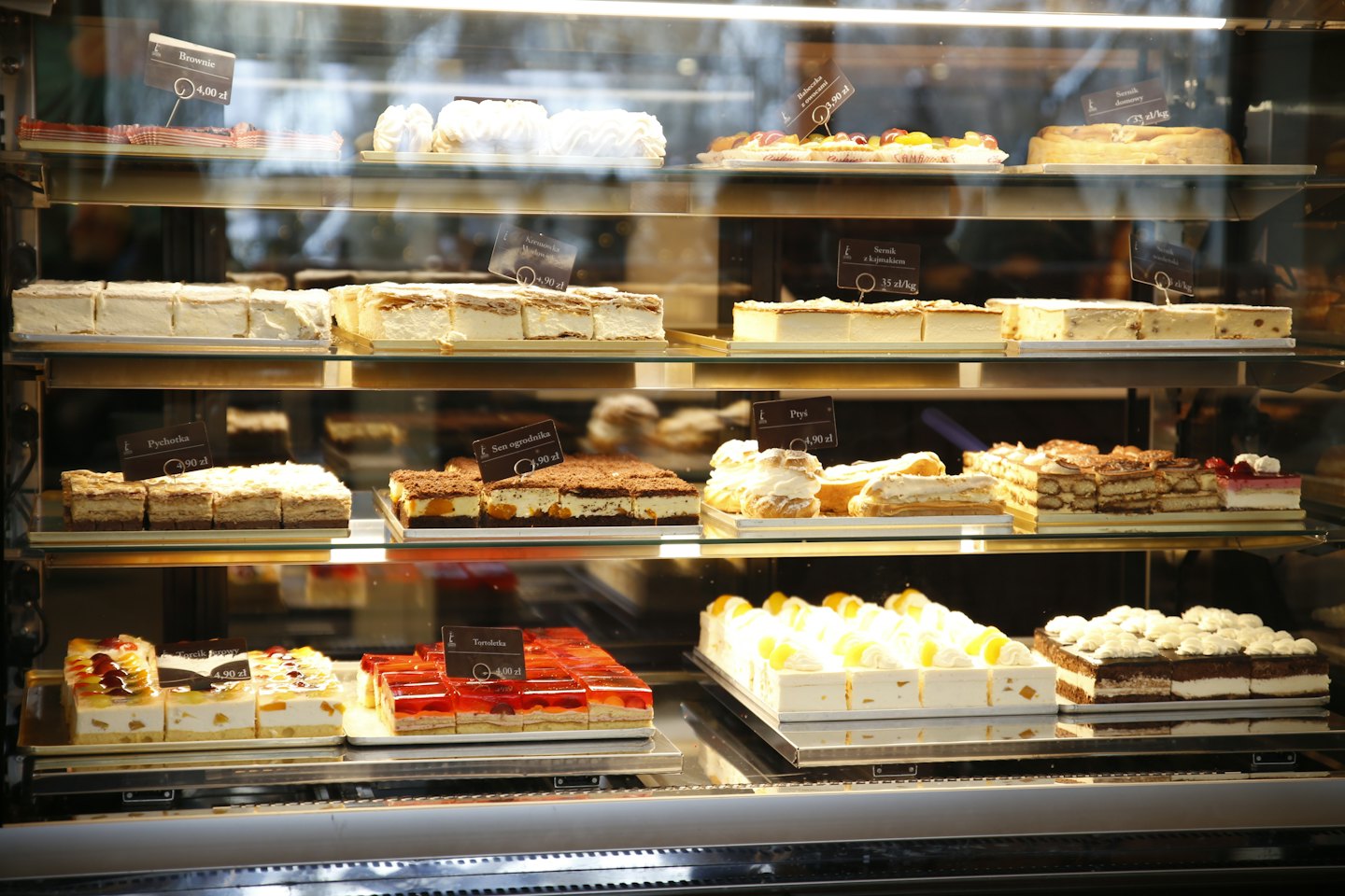 Assorted pastries and cakes displayed inside a glass bakery case.