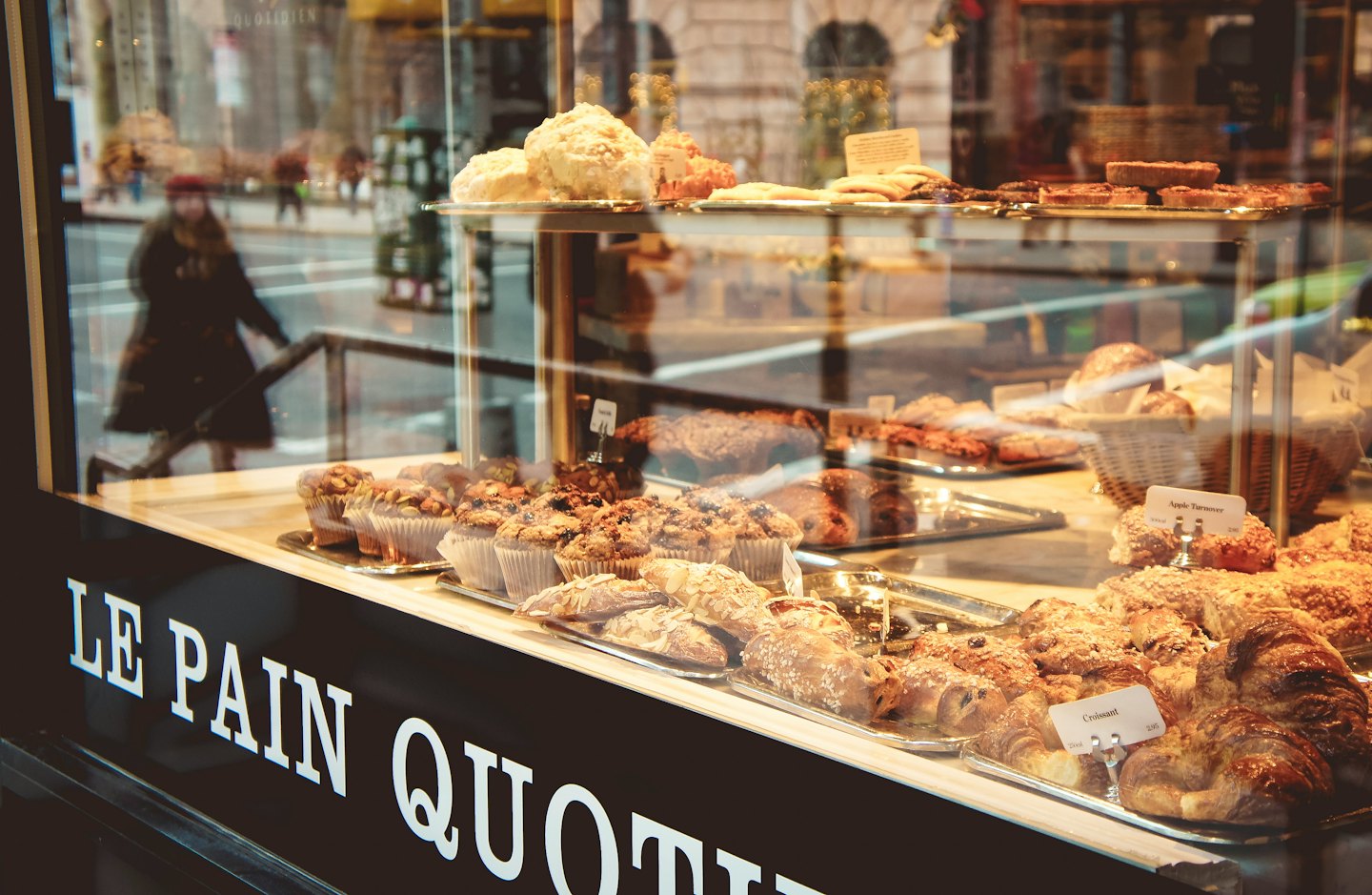 Fresh pastries are displayed on trays in a bakery shop window.